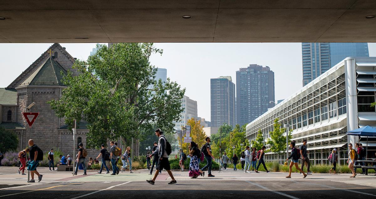 Students walking on campus in front of the Auraria library