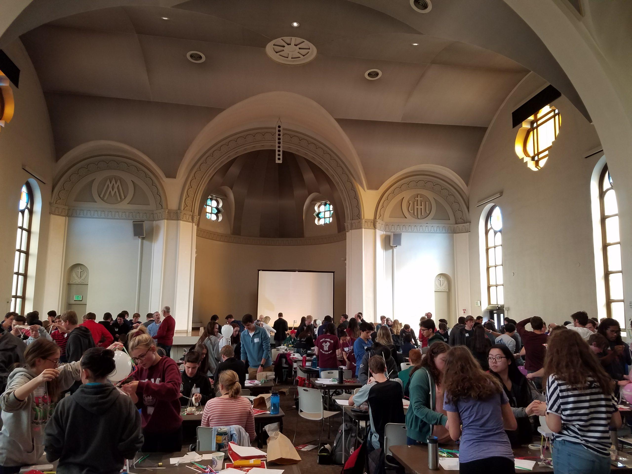 Students gather around tables at the Math day celebration in St. Cajetan's church