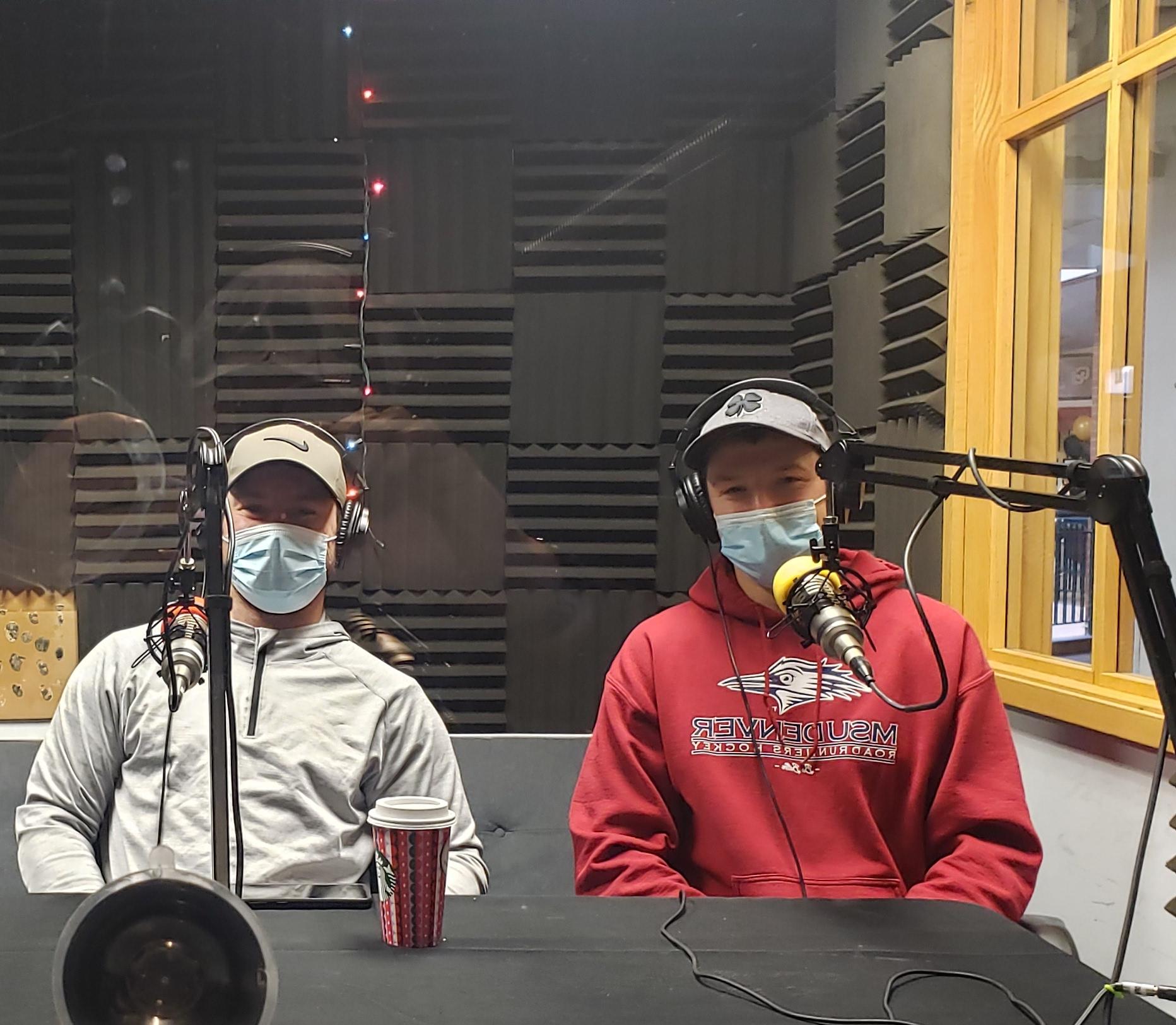 The President and Vice President of the Club Hockey team sitting in the podcast booth with headphones on