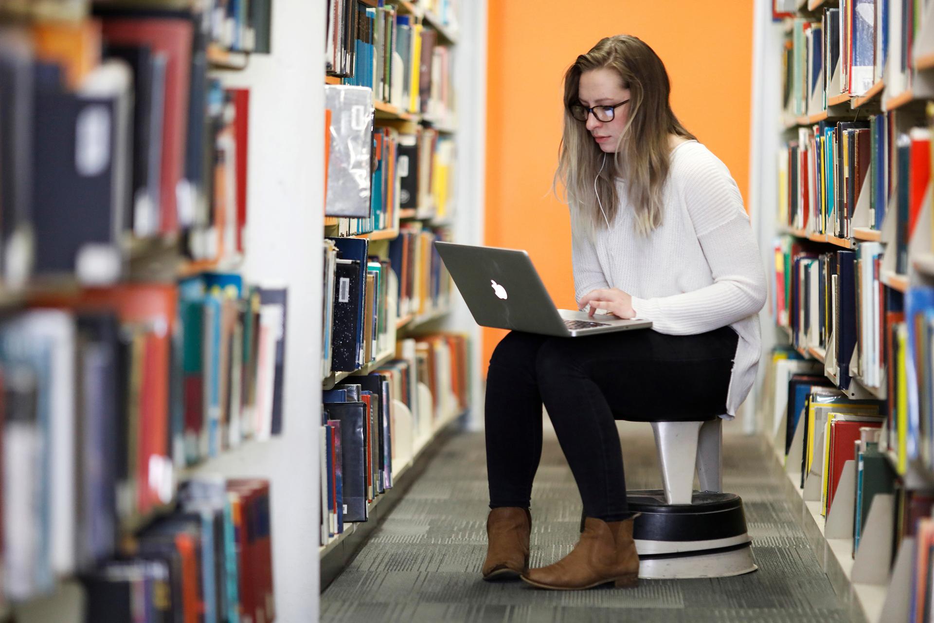 Woman working on laptop computer in library